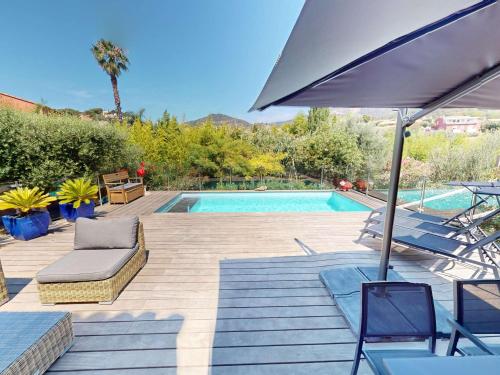 - une piscine avec des chaises et un parasol à côté dans l'établissement Belle villa climatisée avec piscine et parking au Lavandou - FR-1-308-200, au Lavandou