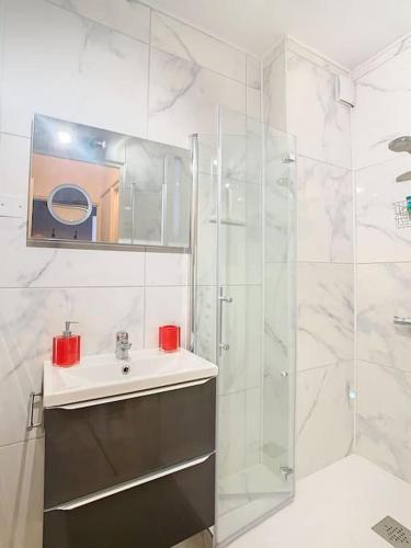 une salle de bain blanche avec un lavabo et une douche dans l'établissement Appartement à 15 minutes de Paris et Parc Expositions de Villepinte de CDG, à Aulnay-sous-Bois