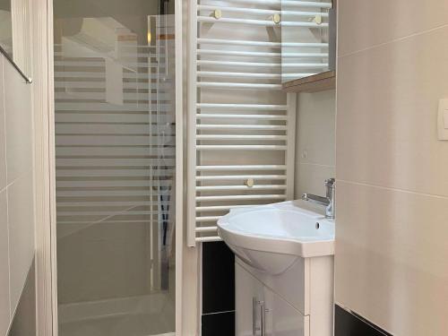 une salle de bain blanche avec un lavabo et une douche dans l'établissement Agréable T2 climatisé avec Loggia, Parking, et Wifi à Balaruc-les-Bains - FR-1-553-250, à Balaruc-les-Bains