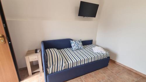 a blue chair with a pillow on it in a room at CAMERA SUL MARE con OMBRELLONE in Lido Di Fondi