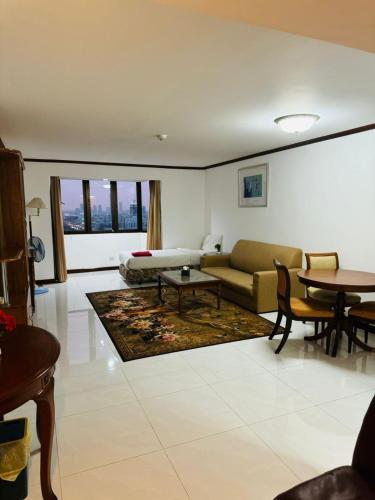 a living room with a couch and a table at Affordable Serviced Apartment Nana - Omni Tower Sukhumvit location in Bangkok