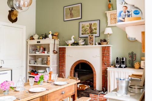 a kitchen with a table and a fireplace at Séminaire,famille,amis,15 couchages, proche plages in Saint-Gervais