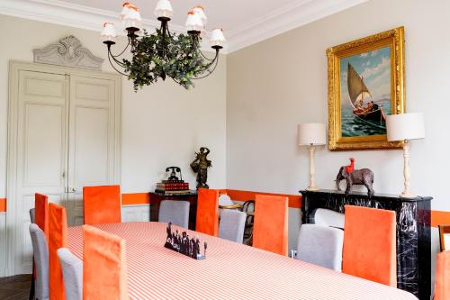 a dining room with a table and orange chairs at Séminaire,famille,amis,15 couchages, proche plages in Saint-Gervais