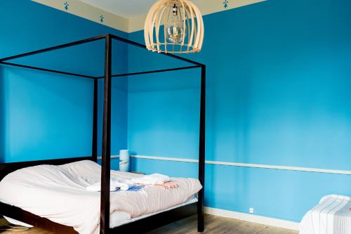 a blue room with a bed with a black frame at Séminaire,famille,amis,15 couchages, proche plages in Saint-Gervais