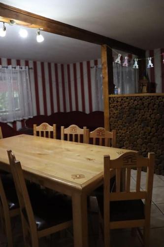 a wooden table and chairs in a room at Cabană în inima munților - Gálkuti Kulcsosház in Bălan