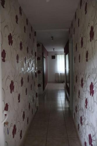 a hallway with flowers on the walls of a room at Cabană în inima munților - Gálkuti Kulcsosház in Bălan