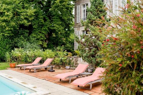 a row of pink lounge chairs next to a swimming pool at Séminaire,famille,amis,15 couchages, proche plages in Saint-Gervais