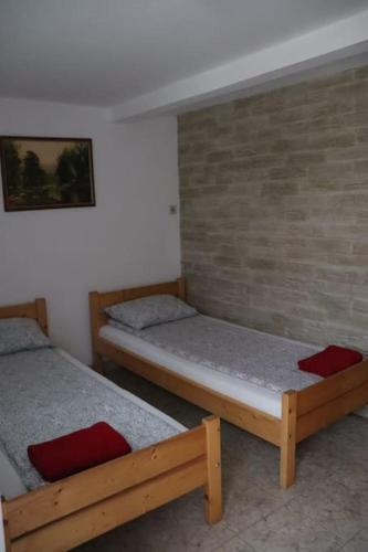 two beds in a room with a brick wall at Cabană în inima munților - Gálkuti Kulcsosház in Bălan
