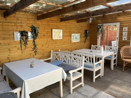 a patio with tables and chairs in a building at Oddevej 20 Skagen in Skagen