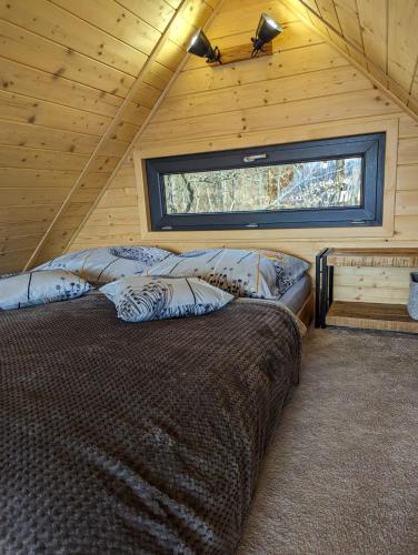 ein Schlafzimmer mit einem großen Bett in einer Hütte in der Unterkunft Greenbela in Banská Belá
