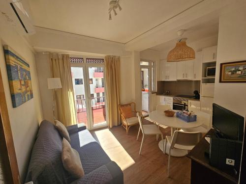 a living room with a blue couch and a table at Apartamento Sunshine in Monte Gordo