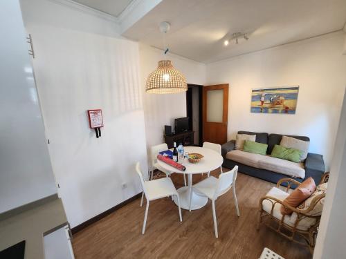 a living room with a table and chairs and a couch at Apartamento Sunshine in Monte Gordo
