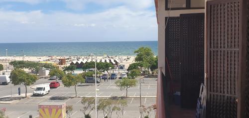 a view of a parking lot and the ocean from a building at Apartamento Sunshine in Monte Gordo
