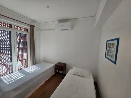 una piccola stanza con due letti e una finestra di Apartamento Sunshine a Monte Gordo