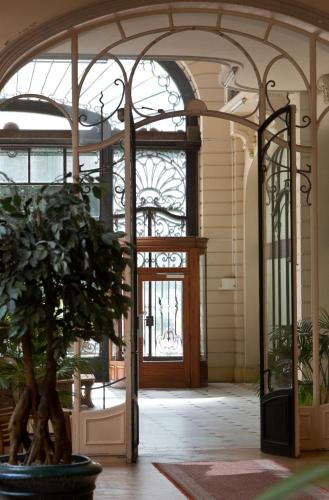 an entrance to a building with a door and a plant at Le Boudoir Monsieur Aurélien - Suite Hôtelière in Le Mont-Dore