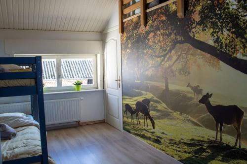 a bedroom with a mural of deer on the wall at Doornhof, rustig gelegen vakantiehuis in Haaltert