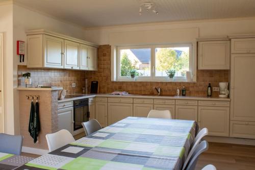 a kitchen with a table and chairs and a window at Doornhof, rustig gelegen vakantiehuis in Haaltert