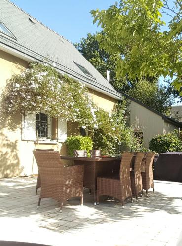 un patio avec une table et des chaises devant une maison dans l'établissement Maison proche mer, à Pleurtuit