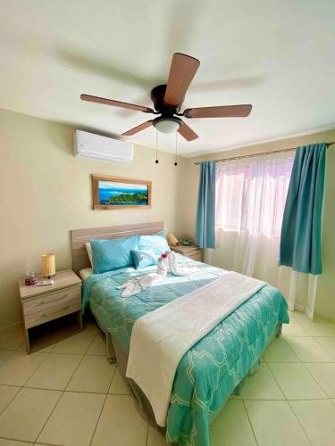 a bedroom with a bed with a ceiling fan at PuraVida Escape - 60 Metres from Beach in Coco
