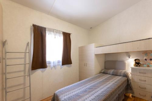 a bedroom with a bunk bed and a window at Camping Village Le Calanchiole in Capoliveri