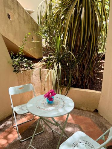a table and two chairs and a table with a flower on it at Turtle's Nest Condo in Liberia