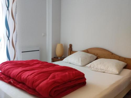a bed with a red blanket on top of it at Chalet Mitoyen 7p avec Piscine, Sauna, Parking Gratuit et Proche Commerces - FR-1-504-67 in Le Dévoluy
