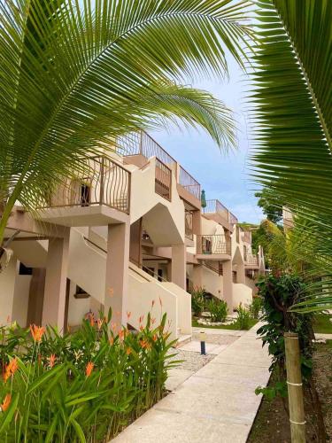a building with a palm tree in front of it at Coco Dream Escapes Ground Unit in Coco