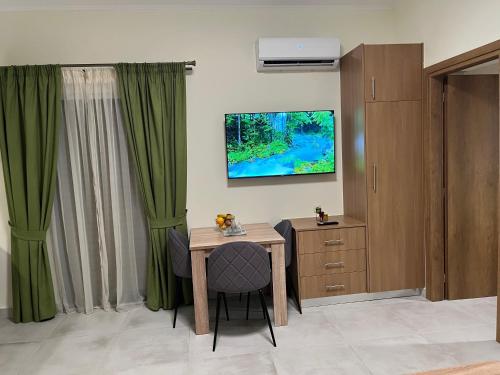 una camera con tavolo e TV a parete di GREENHOUSE maleme ad Ayiá