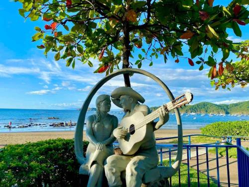 a statue of two people playing a guitar on the beach at Sunny Tropical Condo And Rooftop Terrace in Coco