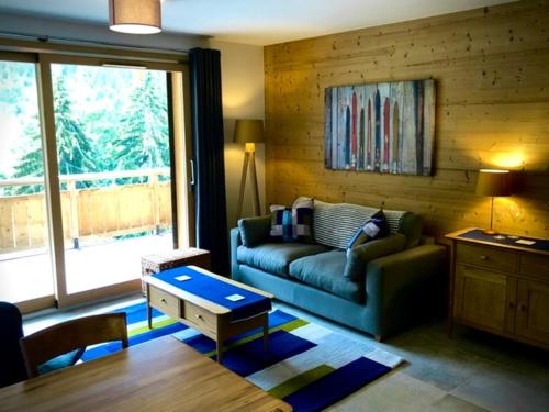 un salon avec un canapé et une table dans l'établissement Appartement 4 personnes Bee on skis à Oz en Oisans, à Oz