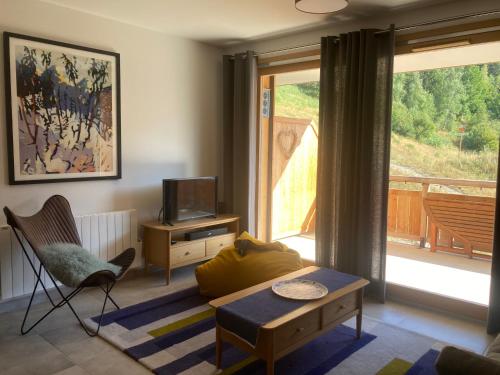 un salon avec un canapé et une télévision dans l'établissement Appartement 4 personnes Bee on skis à Oz en Oisans, à Oz