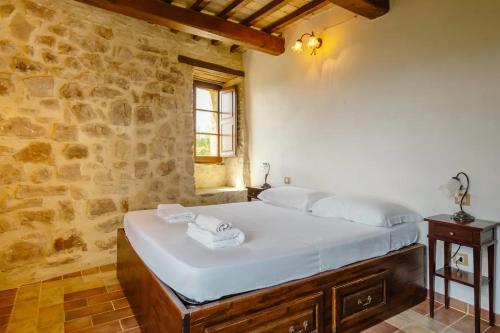 a bed in a room with a stone wall at Castello di Cisterna Uno in Cisterna