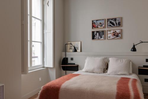 une chambre blanche avec un lit et une fenêtre dans l'établissement Appartement Luxe, Calme et Verdure pour 2, à Paris