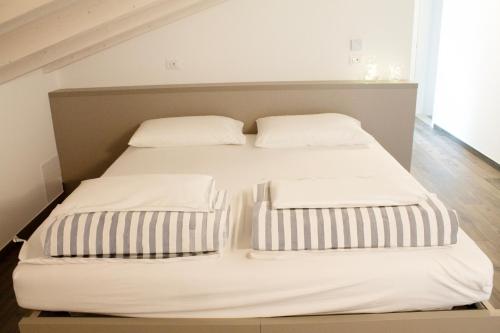 a bed with two pillows on top of it at Soggiorno Bellin in Castel Ivano