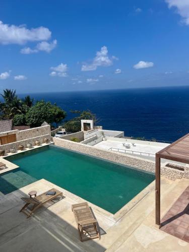 a swimming pool with a view of the ocean at Villa SOWILO Penida in Polilit
