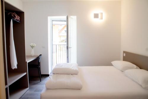 a bedroom with a bed and a desk and a window at Soggiorno Bellin in Castel Ivano
