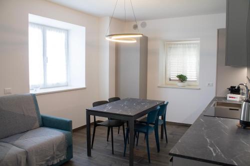a kitchen and dining room with a table and a couch at Soggiorno Bellin in Castel Ivano