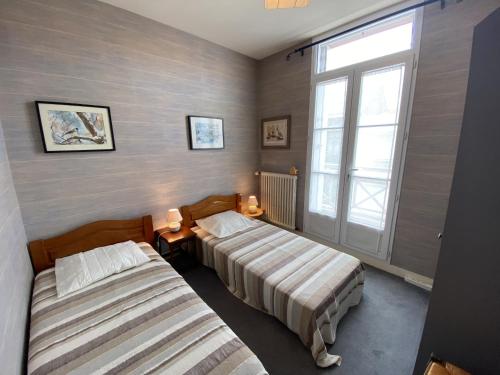 une chambre avec deux lits et une fenêtre dans l'établissement Maison familiale 100m de la plage 