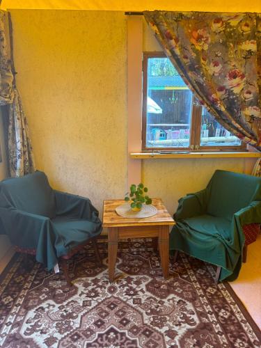 a room with two chairs and a table and a window at Gypsy Camp Apartments & Glamping in Liepāja