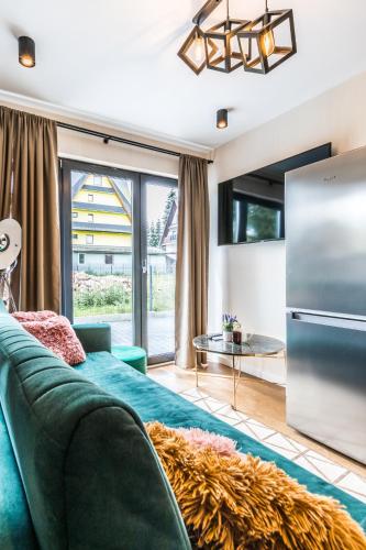 a living room with a green couch and a refrigerator at Aparthome Tatra in Biały Dunajec