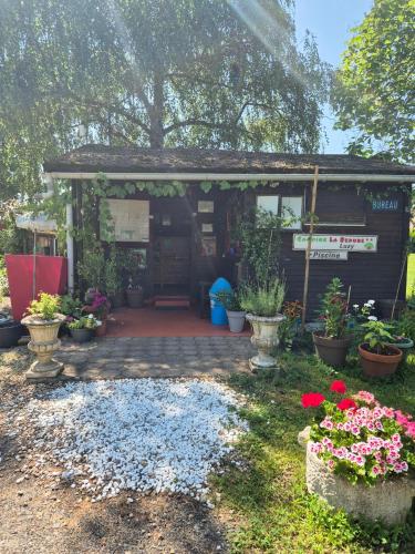 a small house with flowers in a yard at La Bedure in Luzy