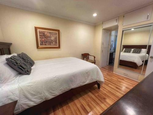 a bedroom with a white bed and a mirror at Pacific Beach Getaway Blocks From The Beach in San Diego