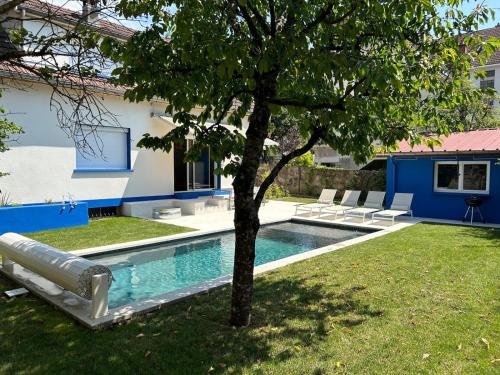 - une piscine avec un arbre à côté d'une maison dans l'établissement Villa Majorelle, à Dijon