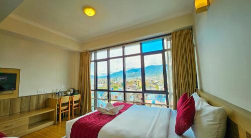 a bedroom with a bed and a large window at Drishya Hotel in Kathmandu