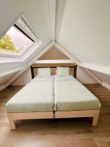 a bed in a small room with a window at Spot Elst vakantiehuis in Elst