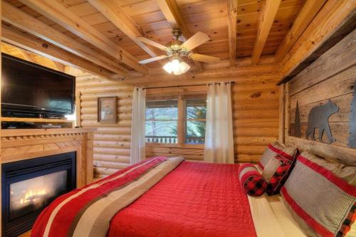 a log cabin bedroom with a bed and a fireplace at Gorgeous Cabin Hot Tub, Fireplace, Great Location in Sevierville