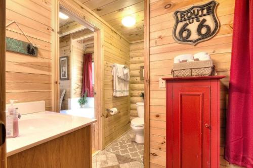 a bathroom with a red door in a wooden cabin at Gorgeous Cabin Hot Tub, Fireplace, Great Location in Sevierville