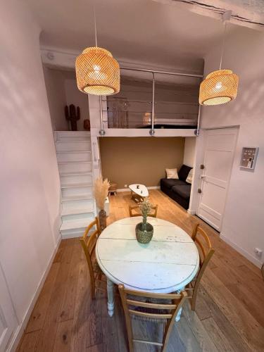 une salle à manger avec une table, des chaises et un canapé dans l'établissement Charmant studio, à Hyères
