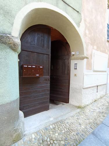 two large wooden doors in a building with an arch at Ortacolorhome GreenHome-Boleto in Madonna del Sasso
