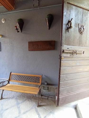 a wooden bench sitting next to a wall at Ortacolorhome GreenHome-Boleto in Madonna del Sasso